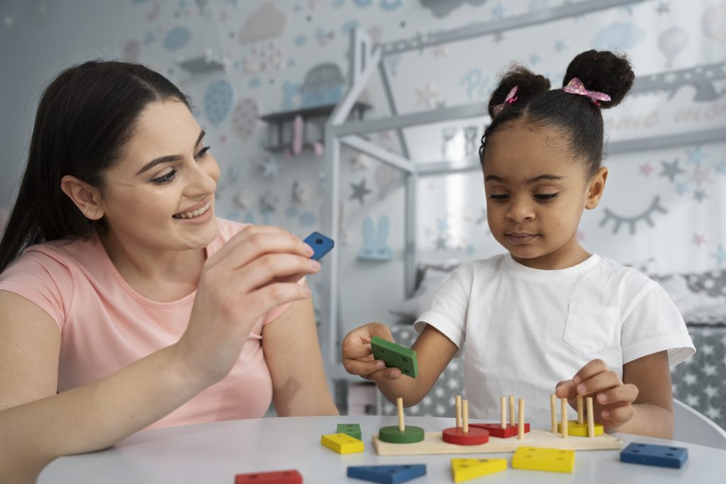 Therapist guiding a child through a hands-on therapy activity with shape blocks